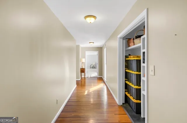 a hallway with wooden floor and closet