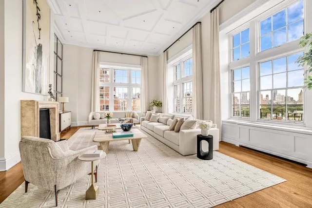 a living room with fireplace furniture and a large window