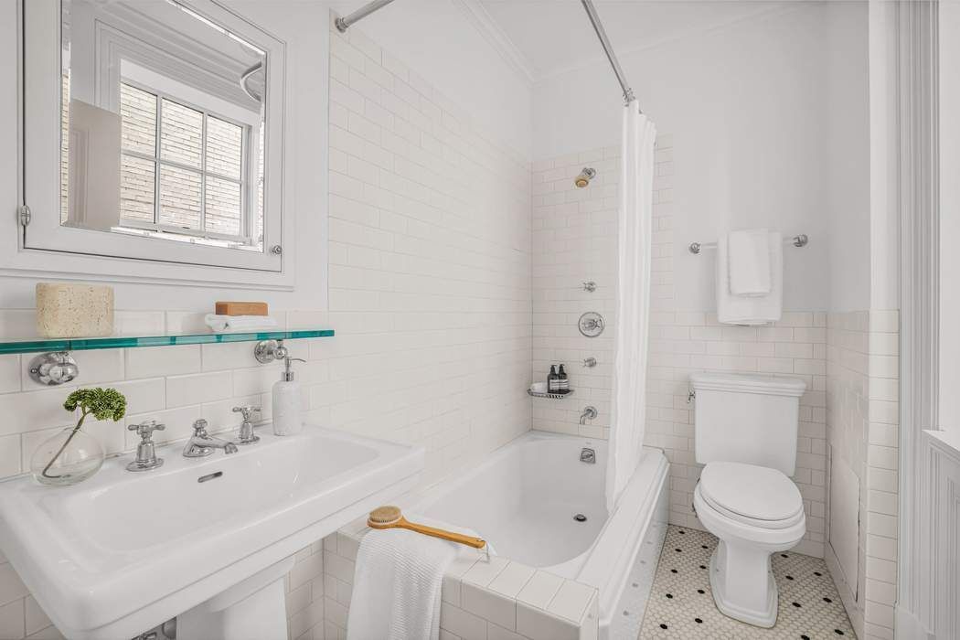 39 East 79th Street, Unit TRIPLEX 12/13/14 Manhattan, NY 10075 - Photo 18 of 33 a bathroom with a sink toilet and shower