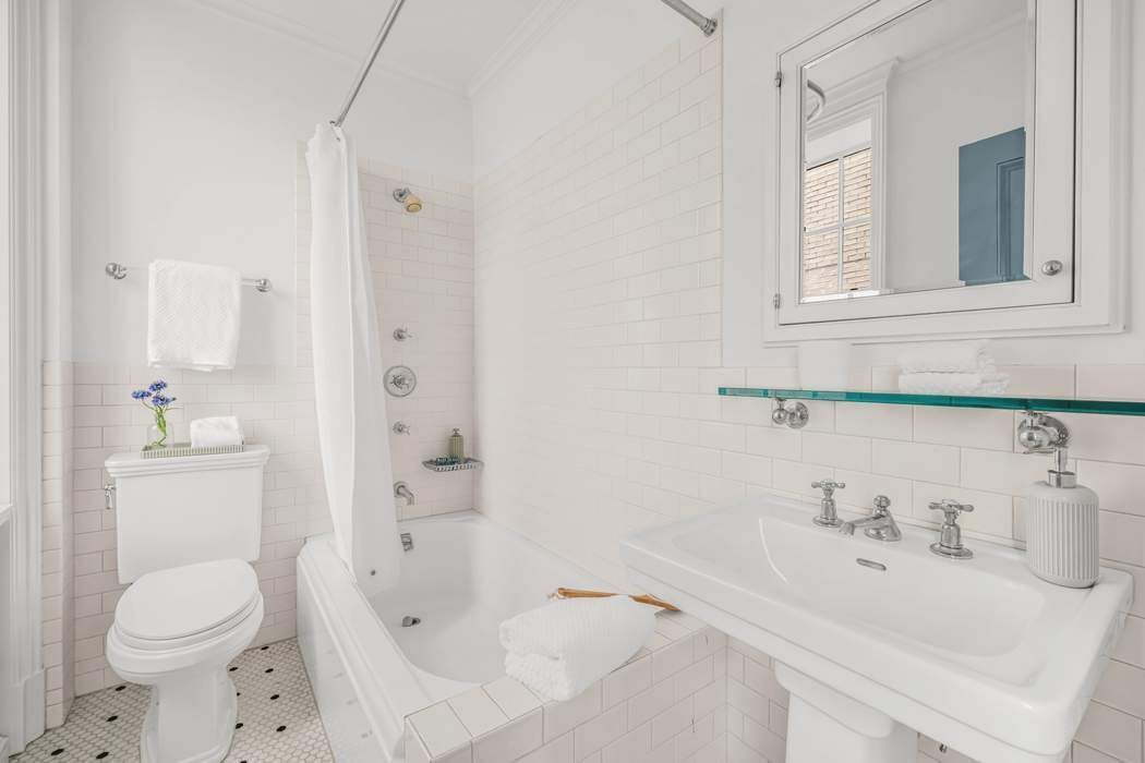 39 East 79th Street, Unit TRIPLEX 12/13/14 Manhattan, NY 10075 - Photo 22 of 33 a bathroom with a sink toilet and shower