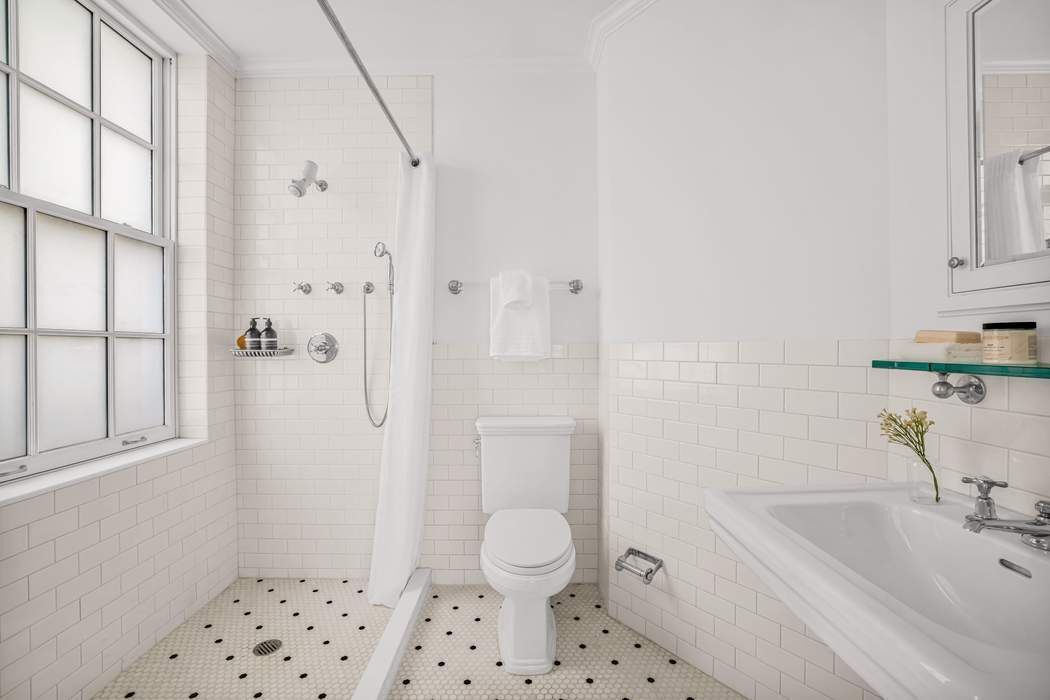 39 East 79th Street, Unit TRIPLEX 12/13/14 Manhattan, NY 10075 - Photo 25 of 33 a bathroom with a sink toilet and shower