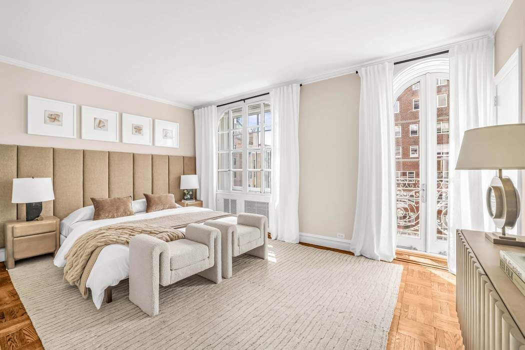 39 East 79th Street, Unit TRIPLEX 12/13/14 Manhattan, NY 10075 - Photo 27 of 33 a bedroom with a bed next to a large window with the outer view