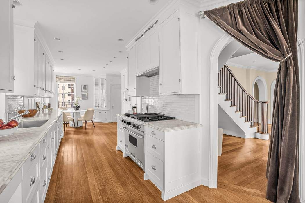 39 East 79th Street, Unit TRIPLEX 12/13/14 Manhattan, NY 10075 - Photo 5 of 33 a kitchen with stainless steel appliances granite countertop a stove a sink and a refrigerator