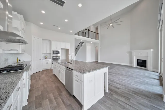 a view of a kitchen and an empty room with wooden floor kitchen view