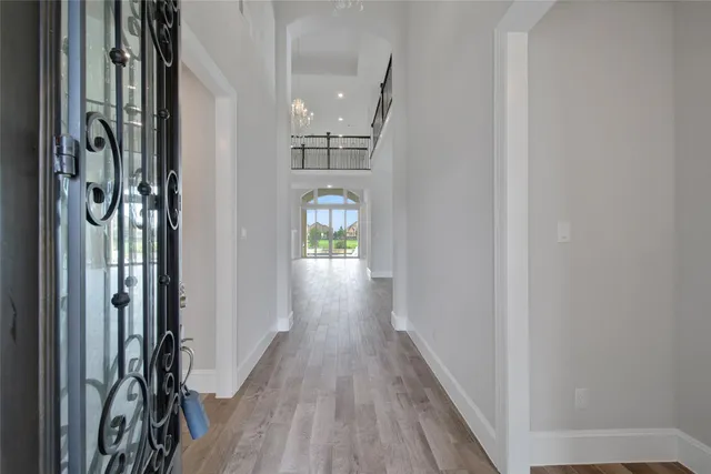 a view of a hallway with wooden floor and staircase