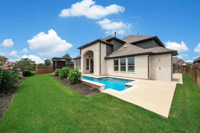 a view of an house with swimming pool patio and a garden