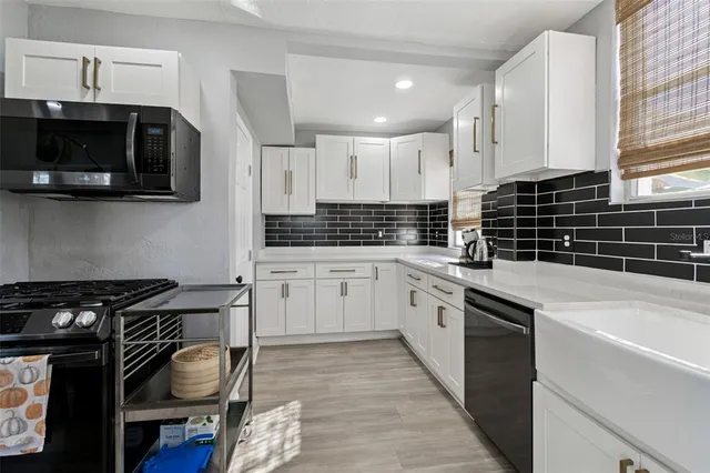 a kitchen with stainless steel appliances a stove a sink and a microwave