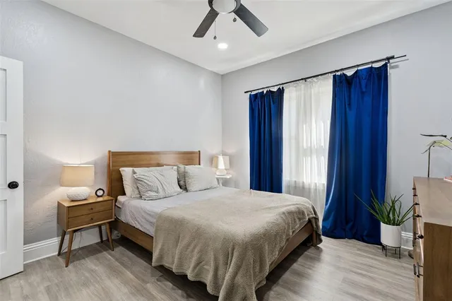 a bedroom with a bed and a flat tv screen on a dresser
