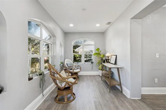 a living room with furniture flowerpot and wooden floor