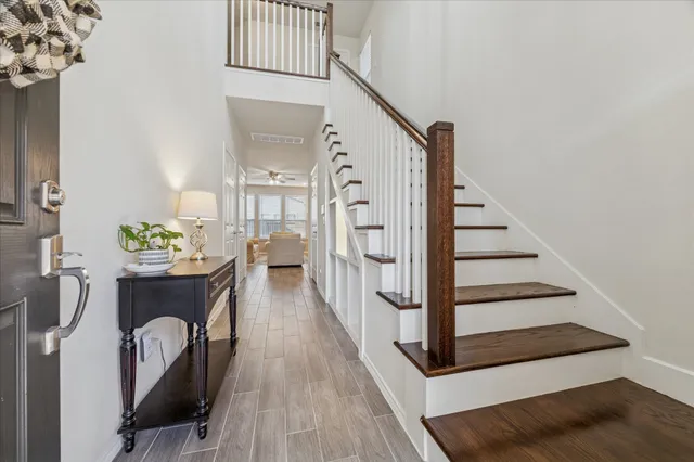 a view of a hallway with furniture and wooden floor