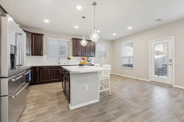 a kitchen with kitchen island granite countertop a sink counter top space appliances and cabinets