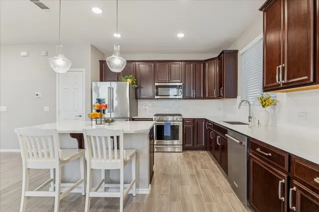a kitchen with stainless steel appliances a sink stove and refrigerator