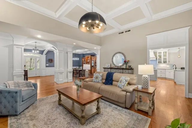 a kitchen with stainless steel appliances kitchen island granite countertop a stove a sink a dining table and chairs with wooden floor