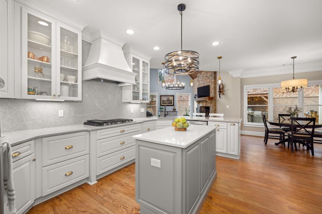 99 Madeline Anthony Road Dahlonega, GA 30533 - Photo 17 of 60 a kitchen with stainless steel appliances kitchen island granite countertop a stove a sink a dining table and chairs with wooden floor