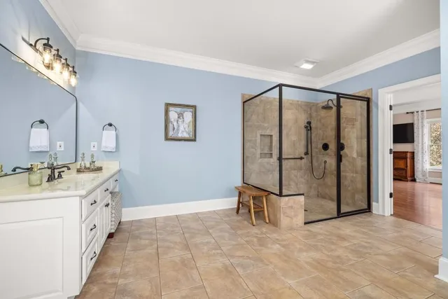 a bathroom with a sink a toilet a mirror and shower