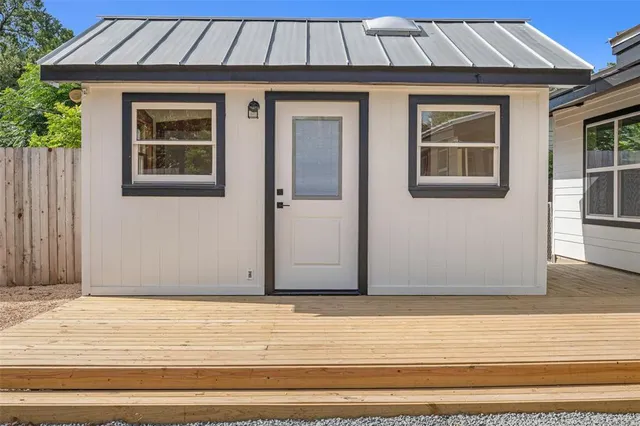 a front view of a house with a yard and potted plants