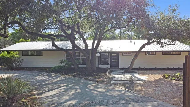 a view of a house with a yard tree and a fence