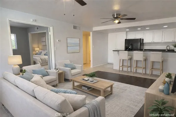 a living room with furniture and a view of kitchen