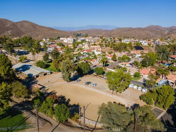 an aerial view of a town with swimming pool and mountains