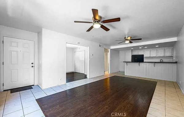 a view of a living room with wooden floor and a ceiling fan