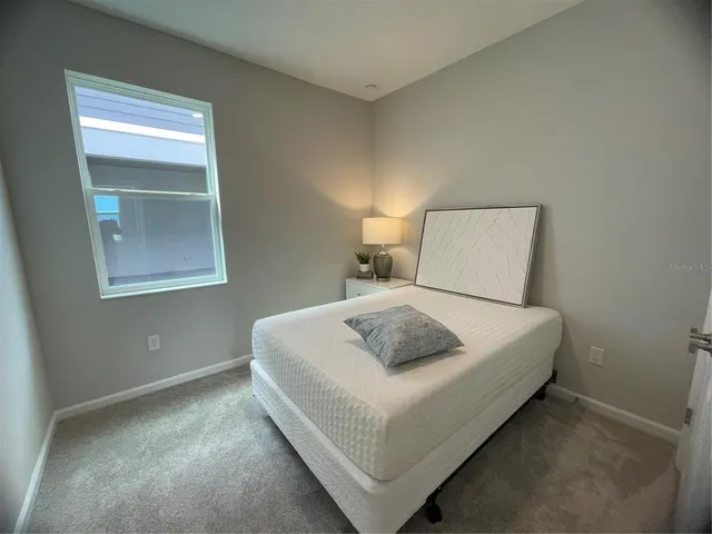 a bedroom with a bed and a night stand