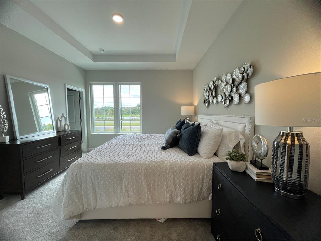 5288 Ctr Lk Rnch Boulevard St. Cloud, FL 34771 - Photo 27 of 31 a bedroom with a bed and dresser with mirror