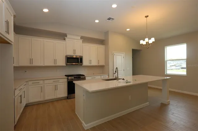 a kitchen with stainless steel appliances granite countertop a sink a stove a refrigerator and cabinets