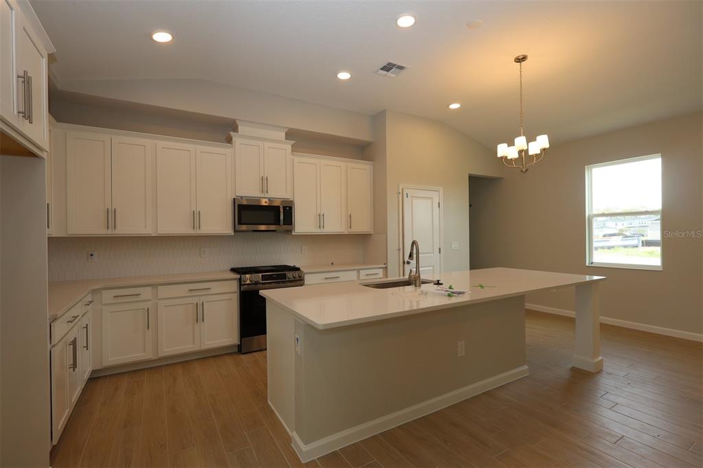 5288 Ctr Lk Rnch Boulevard St. Cloud, FL 34771 - Photo 4 of 31 a kitchen with stainless steel appliances granite countertop a sink a stove a refrigerator and cabinets