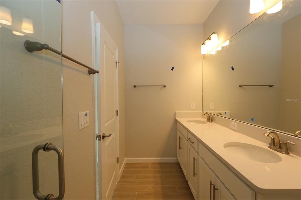 5288 Ctr Lk Rnch Boulevard St. Cloud, FL 34771 - Photo 6 of 31 a bathroom with a double vanity sink a mirror and a shower