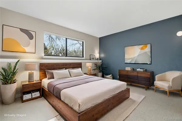 a bedroom with bed and paintings on the wall