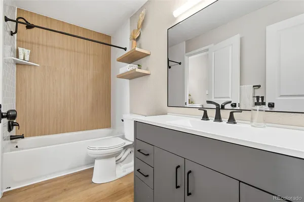 a bathroom with a sink a toilet a mirror and shower