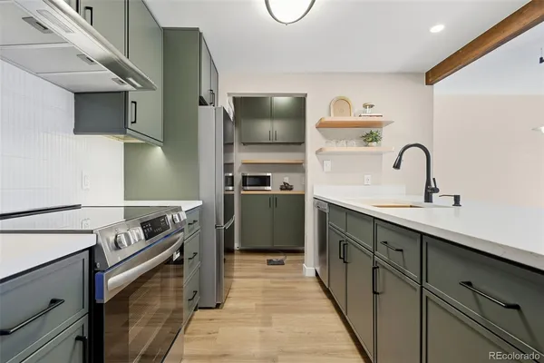 a kitchen with stainless steel appliances granite countertop a sink and a stove top oven