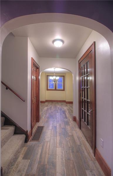 2248 Mercer Road New Brighton, PA 15066 - Photo 2 of 25 New flooring flows throughout and complements the original charm. Coat closet to the right of the stairway. Arched openings.