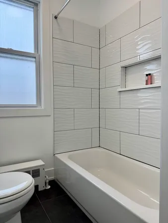 a white bath tub sitting next to a toilet