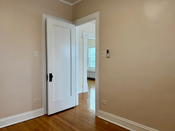 a view of empty room with wooden floor