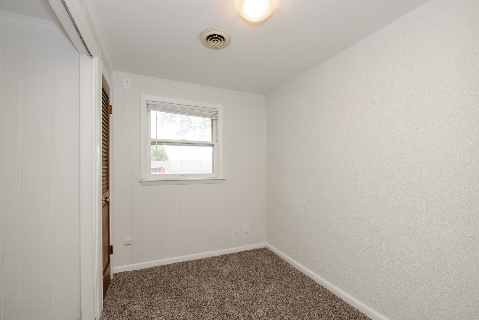 1529 Lewis Street DeKalb, IL 60115 - Photo 13 of 16 an empty room with a window and a fan