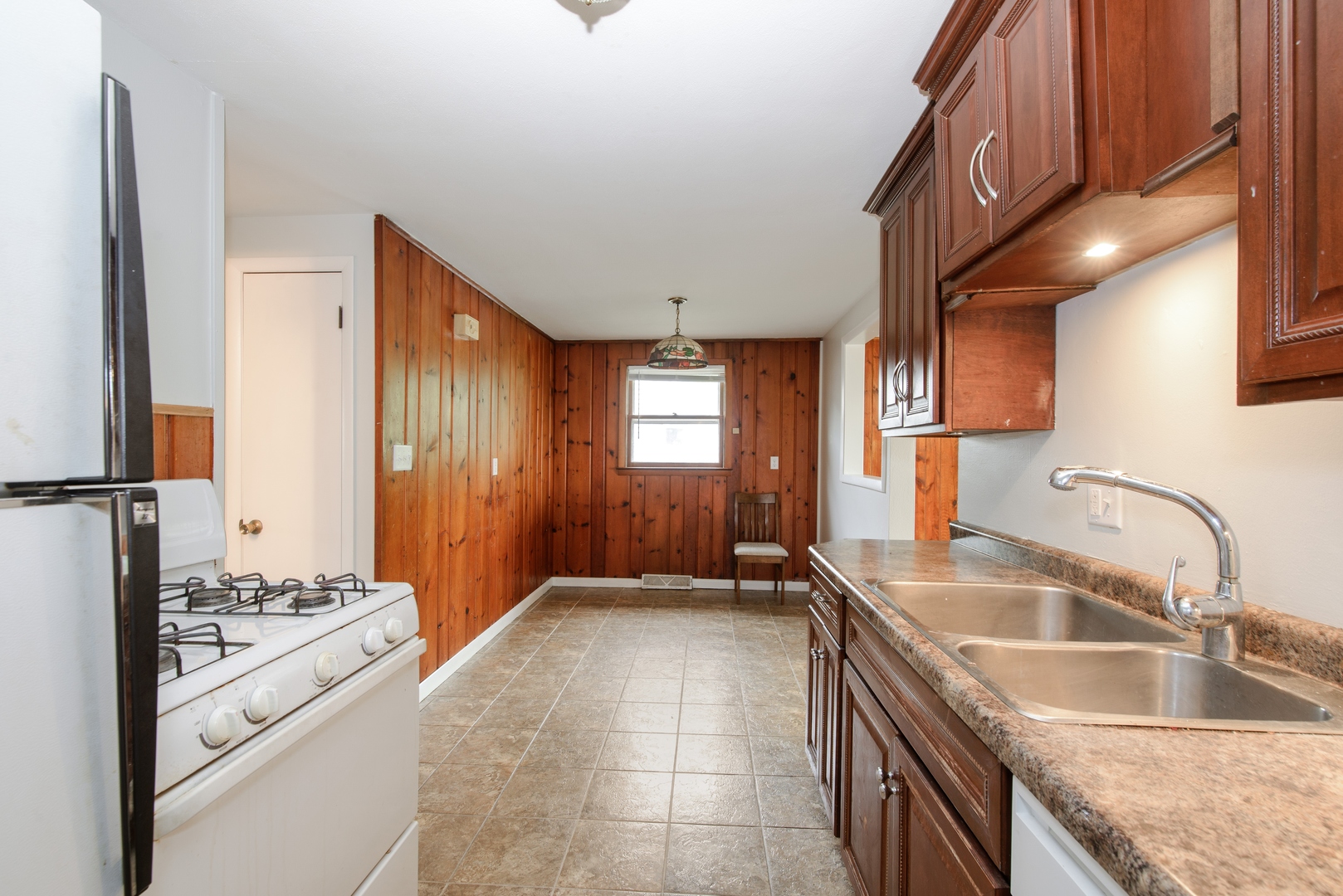 1529 Lewis Street DeKalb, IL 60115 - Photo 5 of 16 a kitchen with granite countertop a sink stove and refrigerator