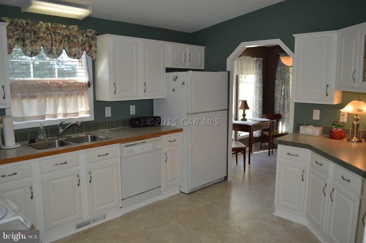 35354 Poplar Neck Road Willards, MD 21874 - Photo 6 of 17 a kitchen with white cabinets and refrigerator