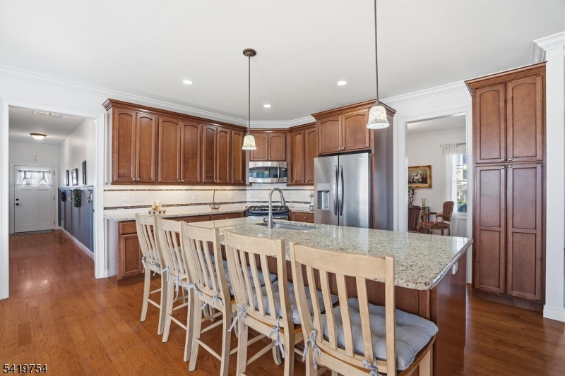 663 Harbor Road Brick, NJ 08724 - Photo 15 of 46 a kitchen with stainless steel appliances granite countertop a refrigerator a stove a sink a dining table and chairs with wooden floor