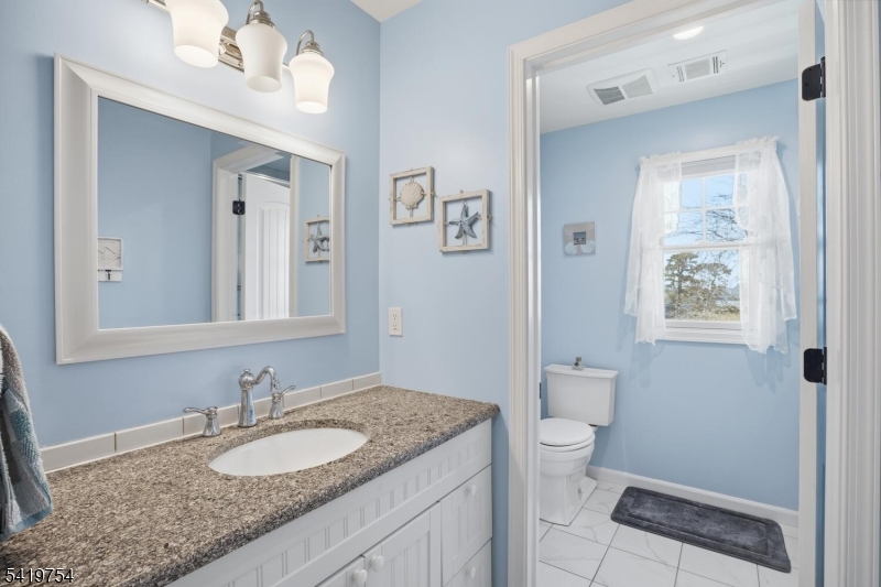 663 Harbor Road Brick, NJ 08724 - Photo 29 of 46 a bathroom with a granite countertop sink and a mirror