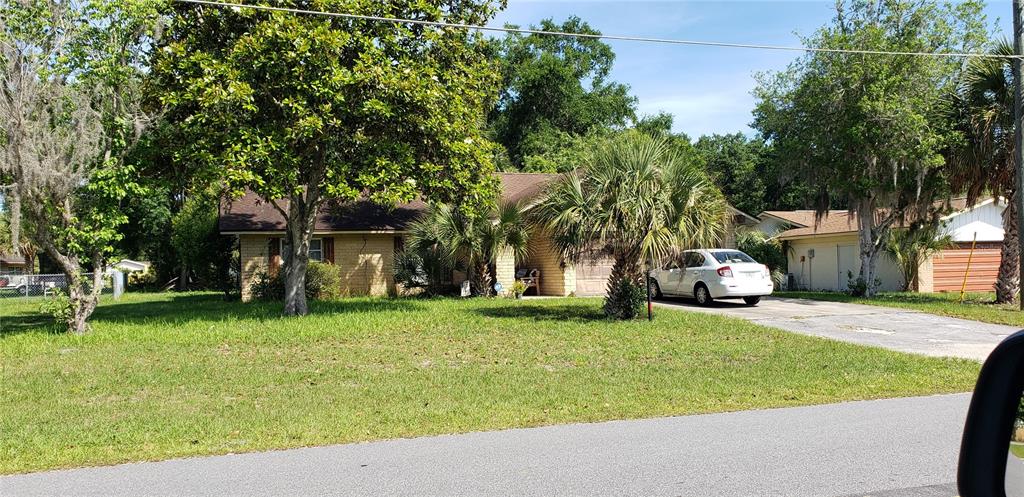 a view of a house with backyard and tree
