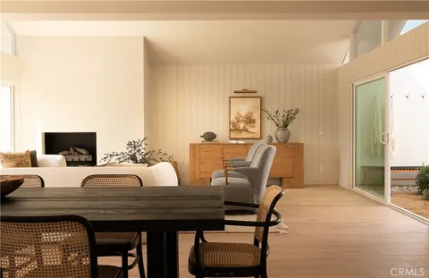 a kitchen with a table chairs and wooden floor