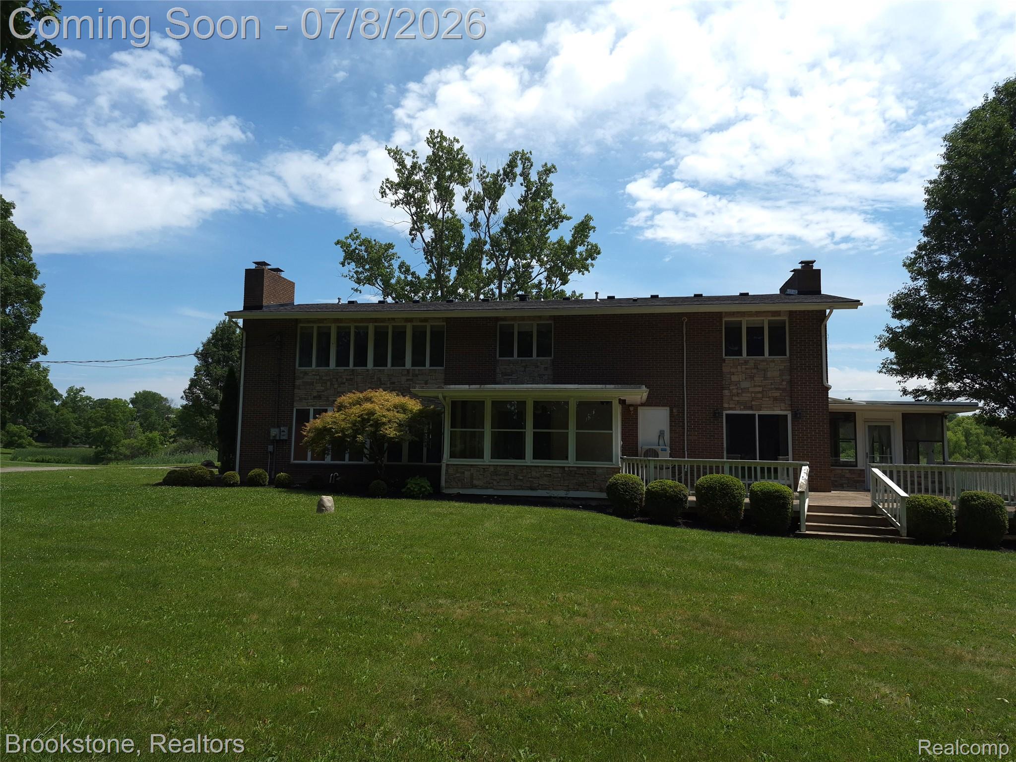 4140 South Henderson Road Davison, MI 48423 - Photo 93 of 98 Brick and stone façade residence featuring a sunroom, multiple windows, and a multi-level deck with white railings