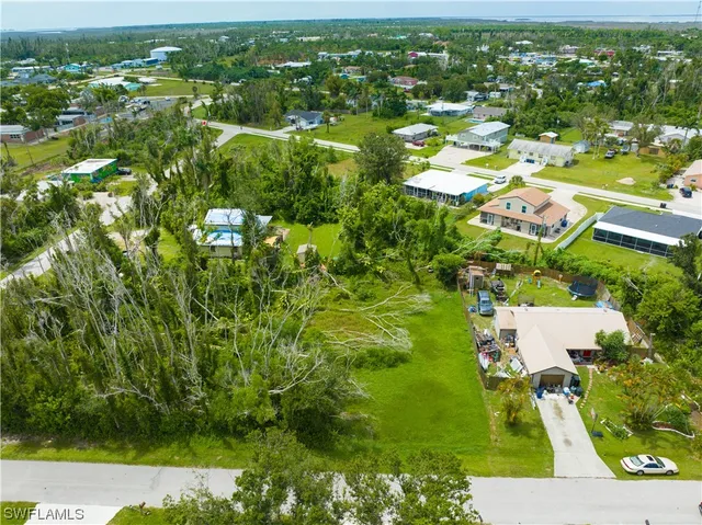 an aerial view of residential houses with outdoor space and trees