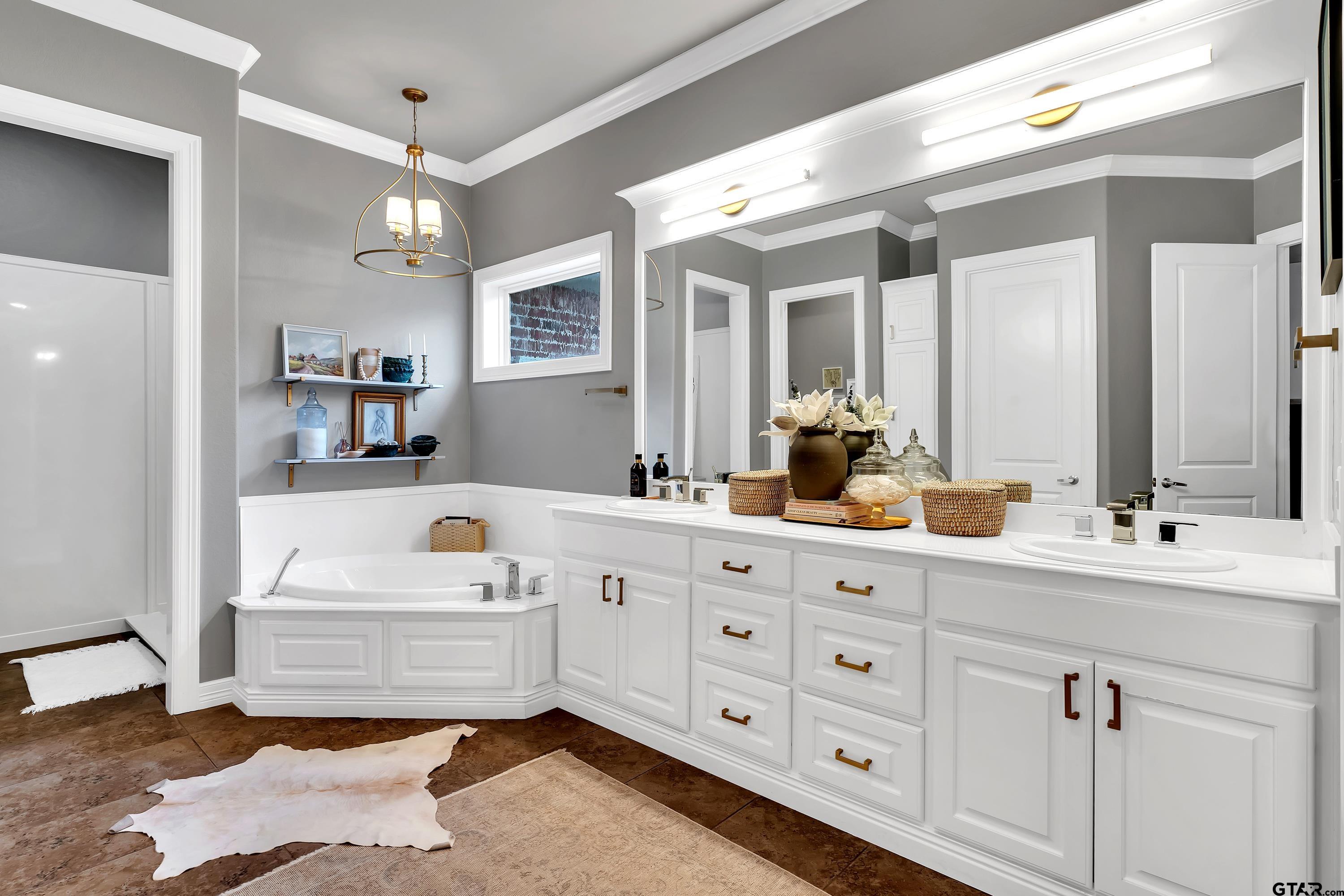 3901 Chase Crest Circle Longview, TX 75605 - Photo 19 of 44 a bathroom with a tub a sink double vanity and a mirror