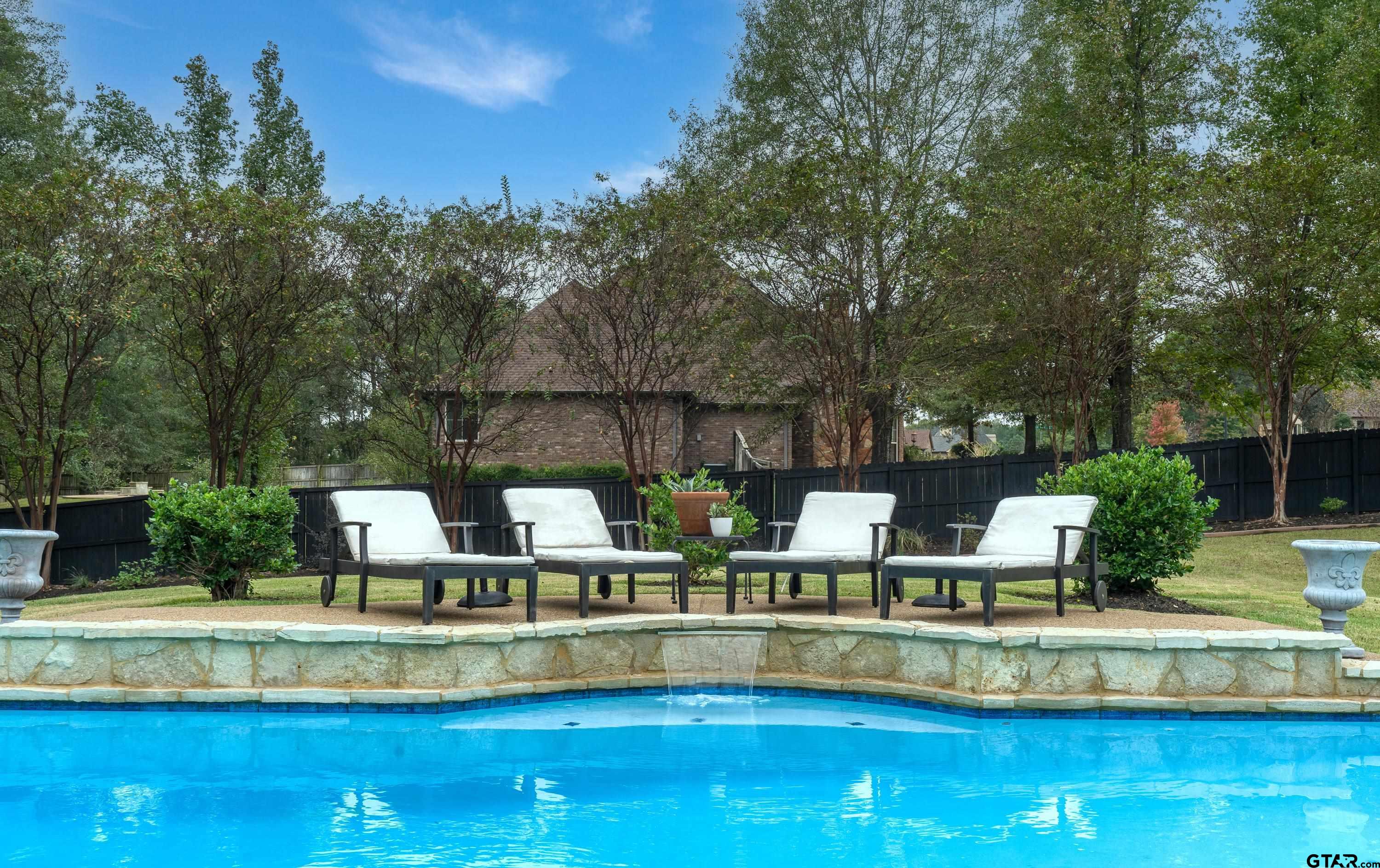 3901 Chase Crest Circle Longview, TX 75605 - Photo 40 of 44 a view of a swimming pool with a bench and trees in the background