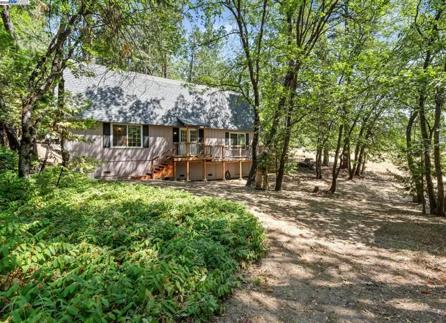 a view of a house with backyard and sitting area