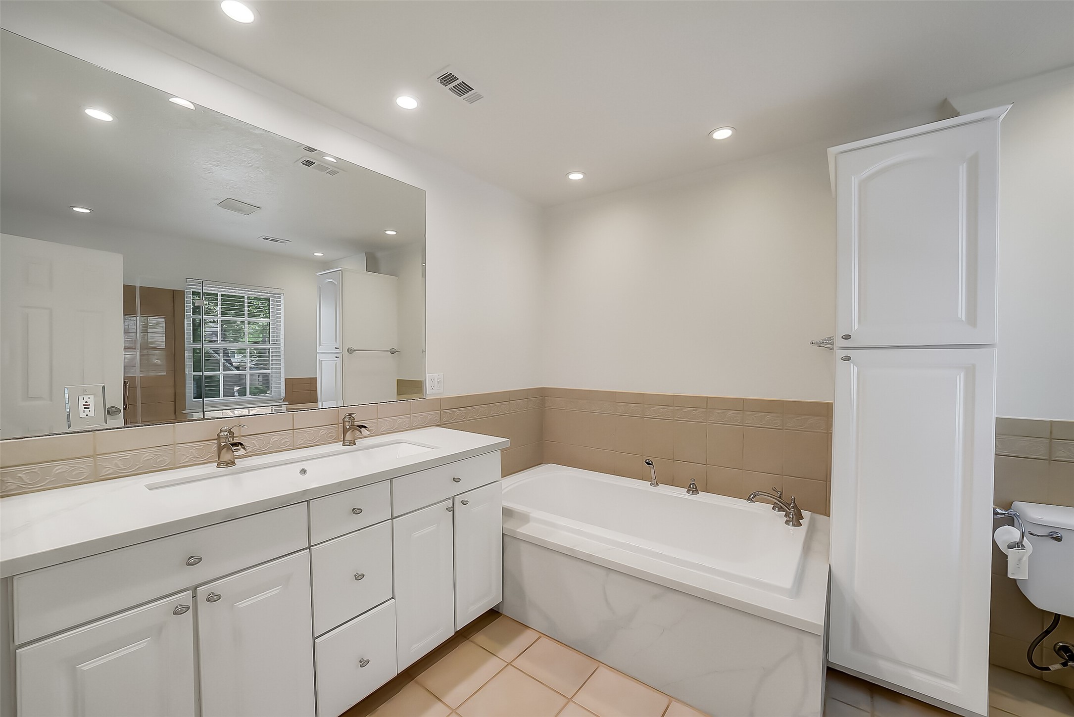 9519 Oxted Lane Spring, TX 77379 - Photo 18 of 40 a bathroom with a bathtub a double vanity sink and mirror