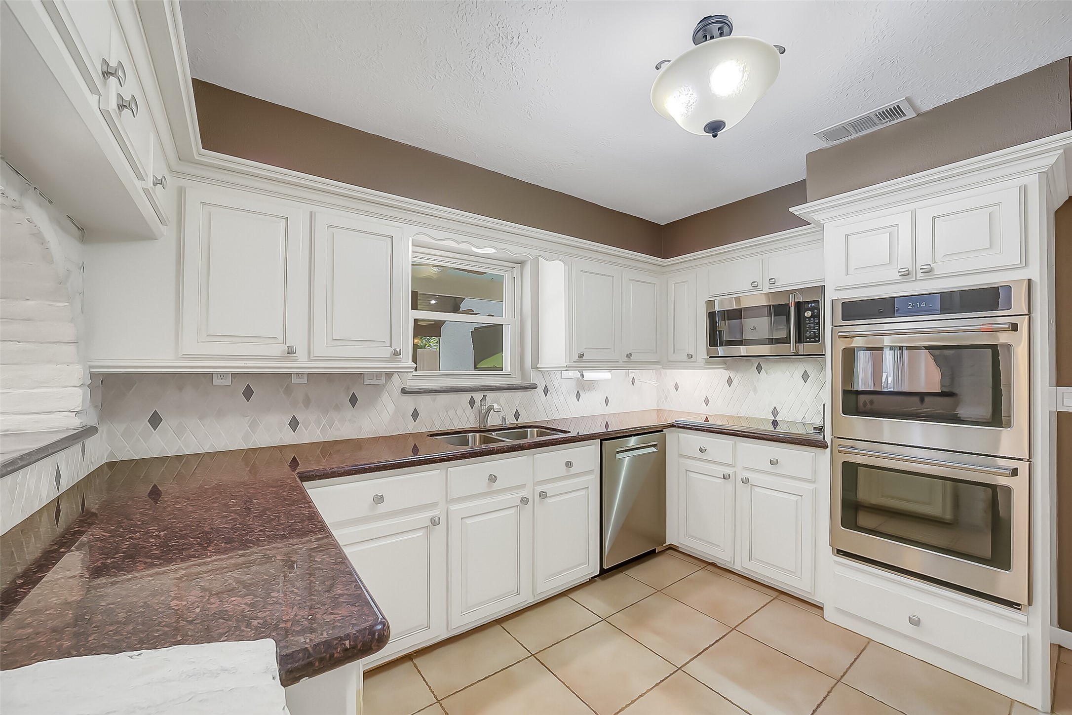 9519 Oxted Lane Spring, TX 77379 - Photo 9 of 40 a kitchen with stainless steel appliances granite countertop a stove sink and cabinets