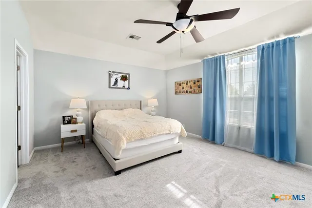 a spacious bedroom with a bed and a chandelier